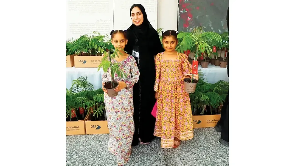 Residents of Dubai receiving free Flame Tree seedlings during a community event.