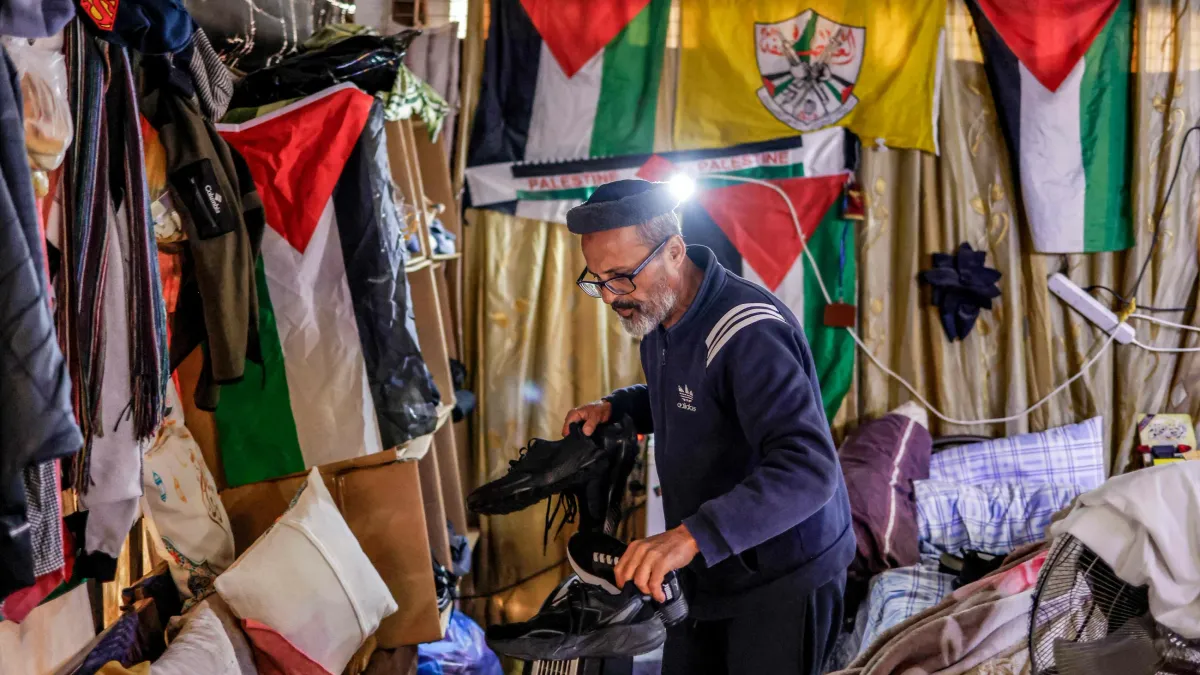 Gaza residents living under bleachers in Nablus stadium, facing difficult conditions.