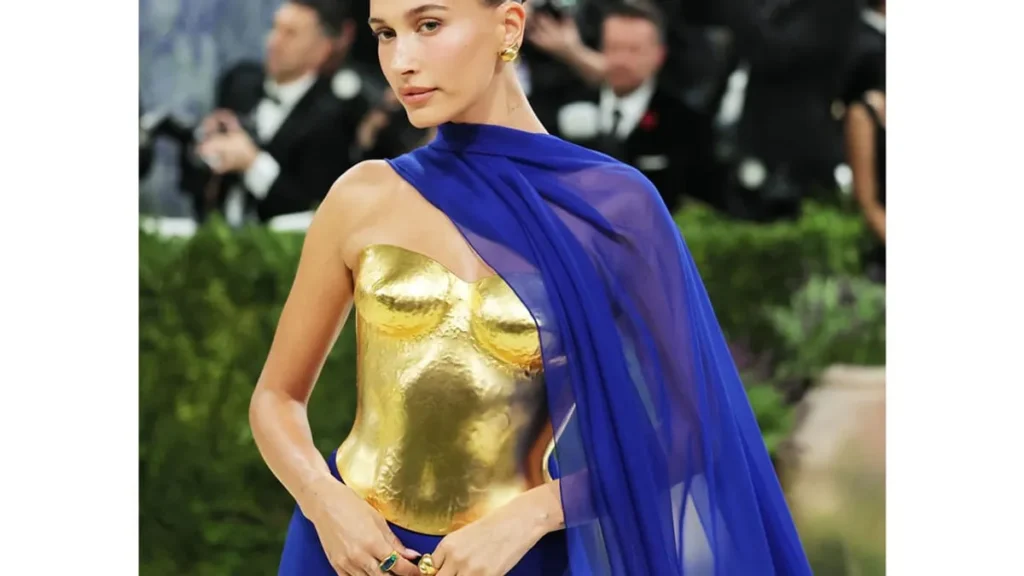 Hailey Bieber at the 2026 Met Gala in a striking gold and cobalt blue outfit.