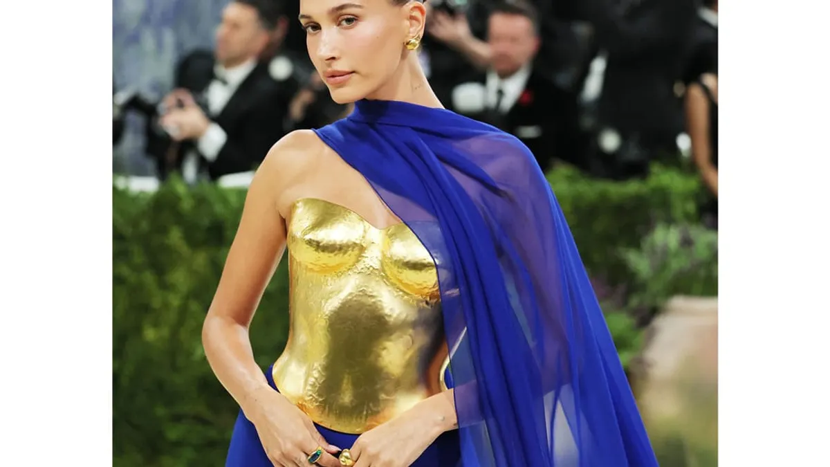 Hailey Bieber at the 2026 Met Gala in a striking gold and cobalt blue outfit.