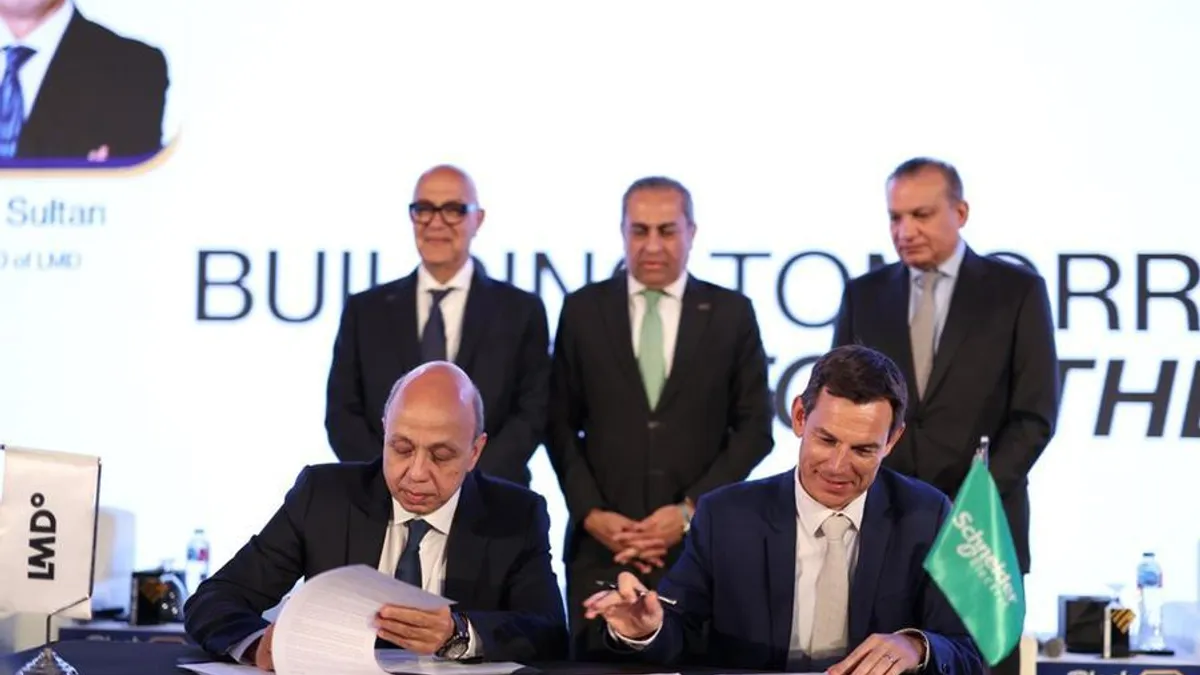 LMD and Schneider Electric executives signing a partnership agreement in Cairo.