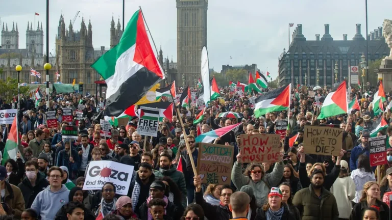 Pro-Palestine protesters marching in London with banners and flags.