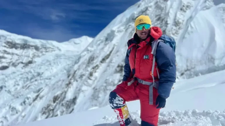 Sajid Sadpara celebrating at the summit of a mountain.